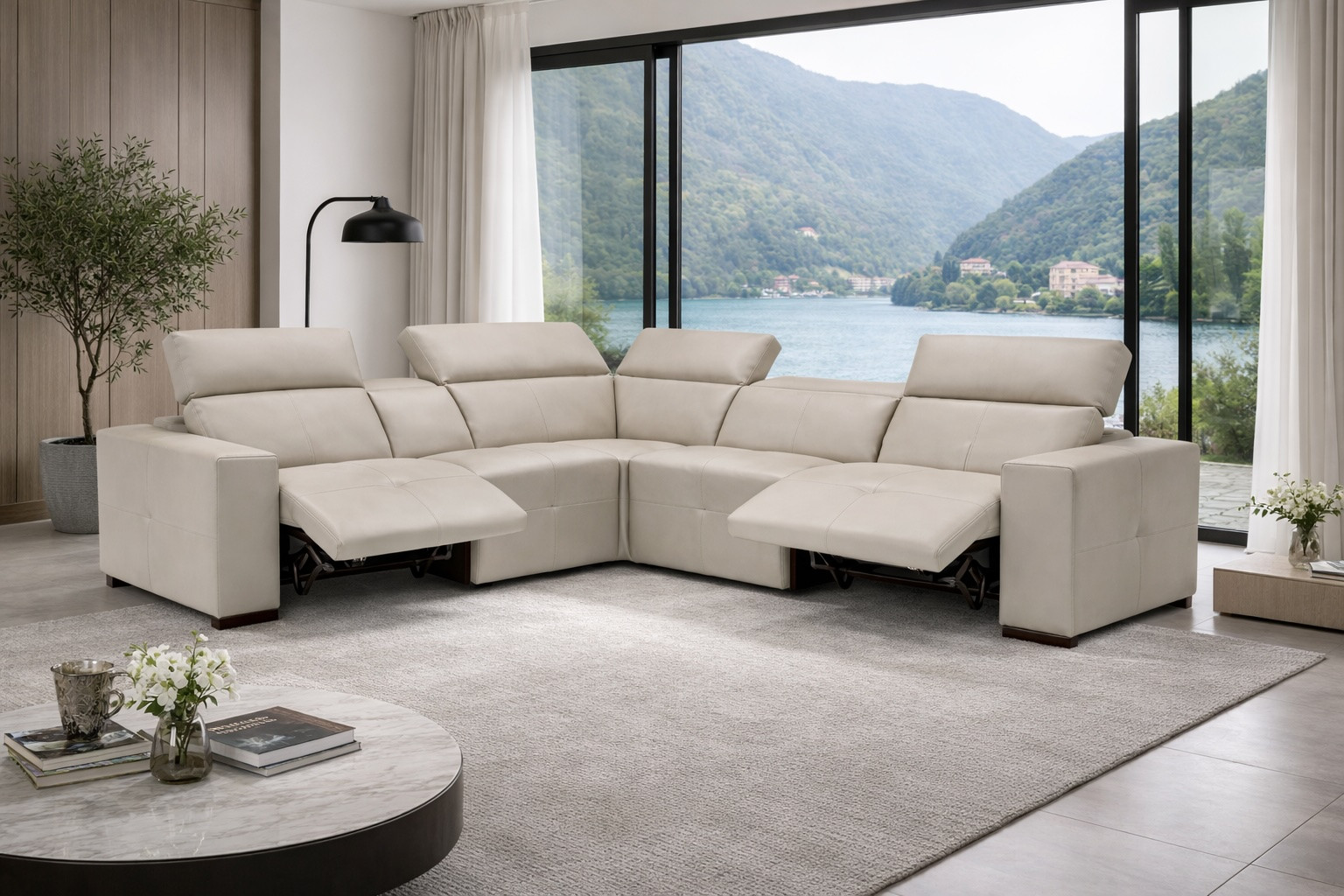 Camilla Italian modular leather sectional sofa with electric recliners and electric headrests, shown in a modern living room with panoramic lake and mountain views.